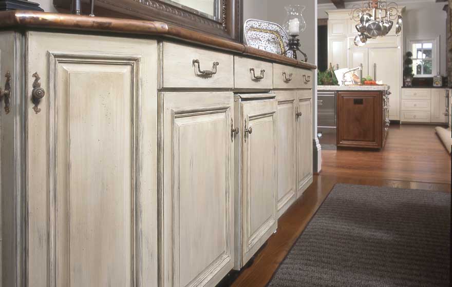 Using a unique paint and glaze application is an excellent option for a dining area hutch leading into a beautiful high end kitchen.