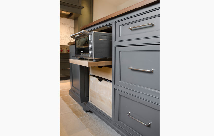 Dark paint creates a dramatic look in this kitchen with all the right custom details.