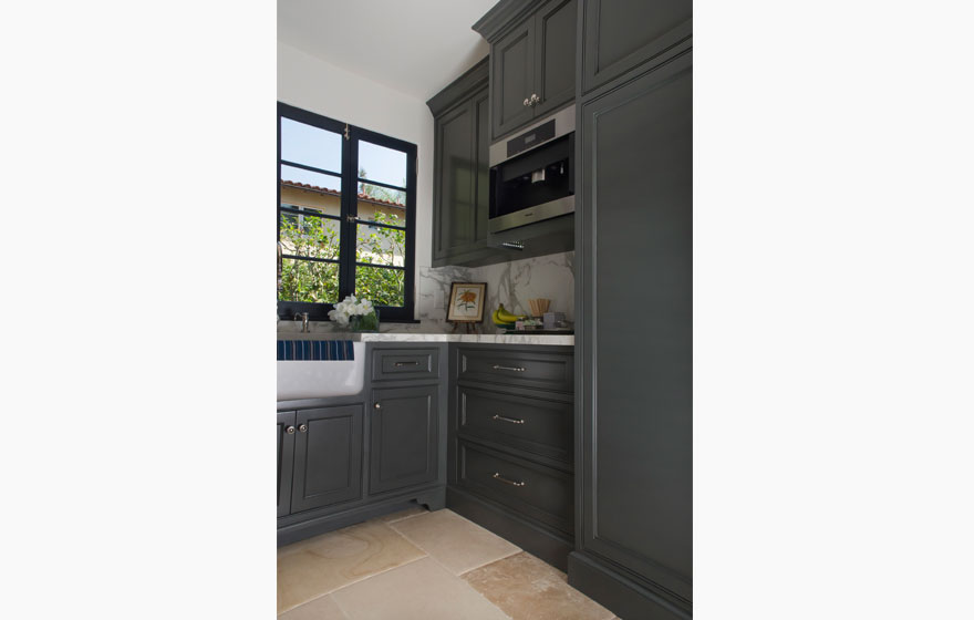 Dark paint creates a dramatic look in this kitchen with all the right custom details.