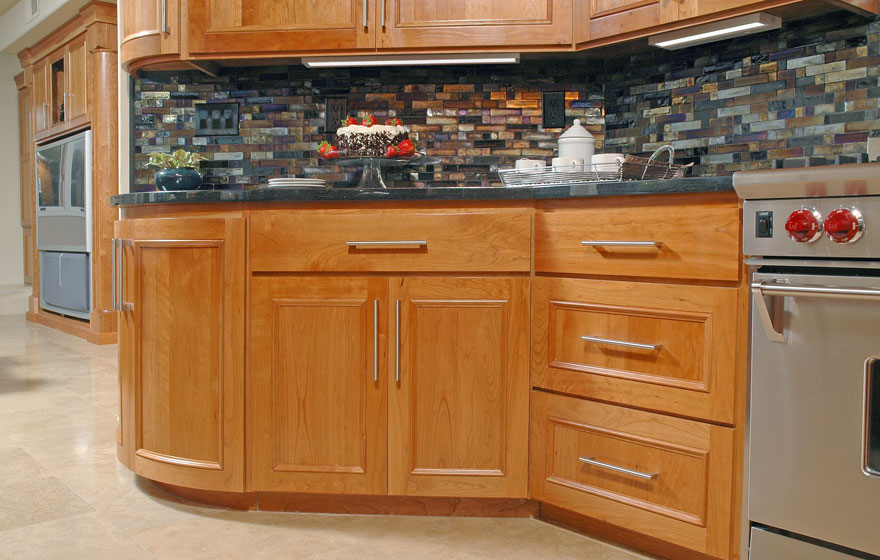 Let the beauty of cherry shine through by using a clear or light stain and using dark tile and granite to make the cabinetry the focal point.