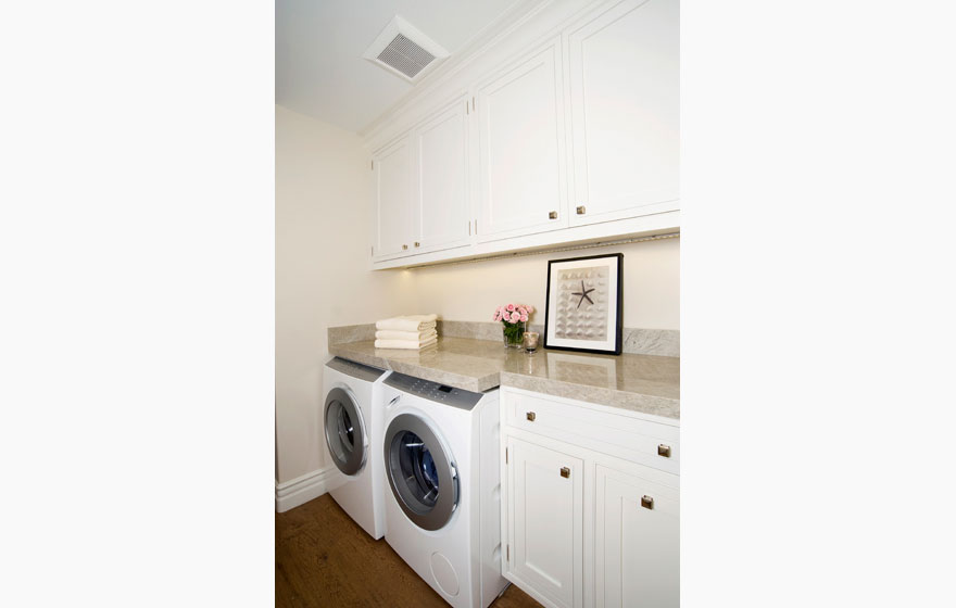 Custom designed wood cabinet doors in a compact laundry room off the kitchen for ease of use.  