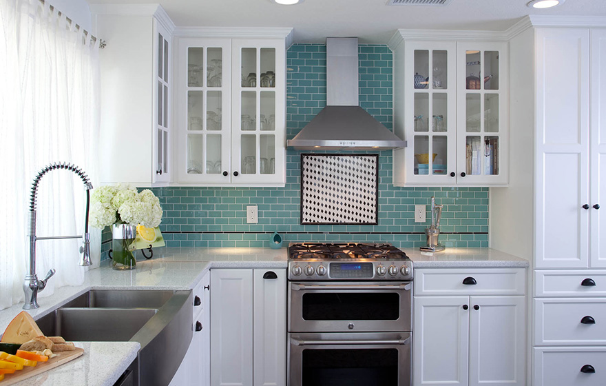 Clean and crisp cabinets pair well with the splash of color in the backsplash.