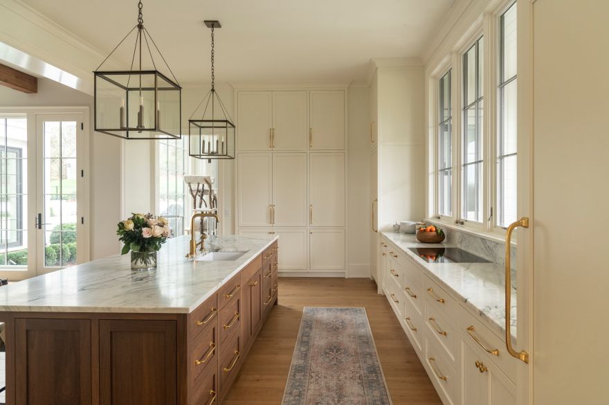 Kitchen island in rich walnut select is accented by painted cabinetry for a warm, eye-catching aesthetic.